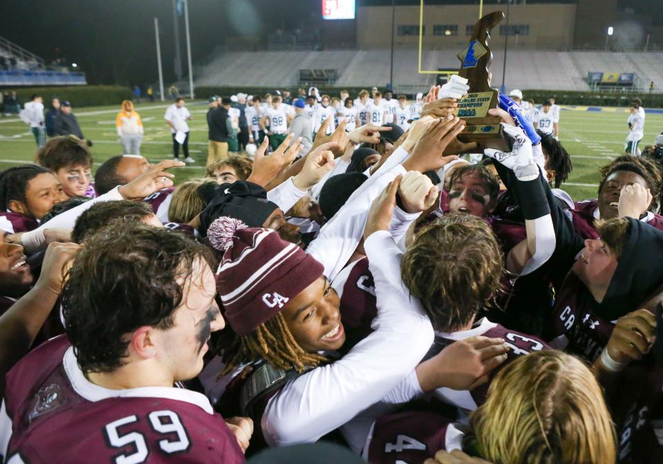 Caravel receives the first place trophy after the Bucs' 35-13 win against Archmere in the DIAA Class 2A championship at Delaware Stadium, Saturday, Dec. 2, 2023.