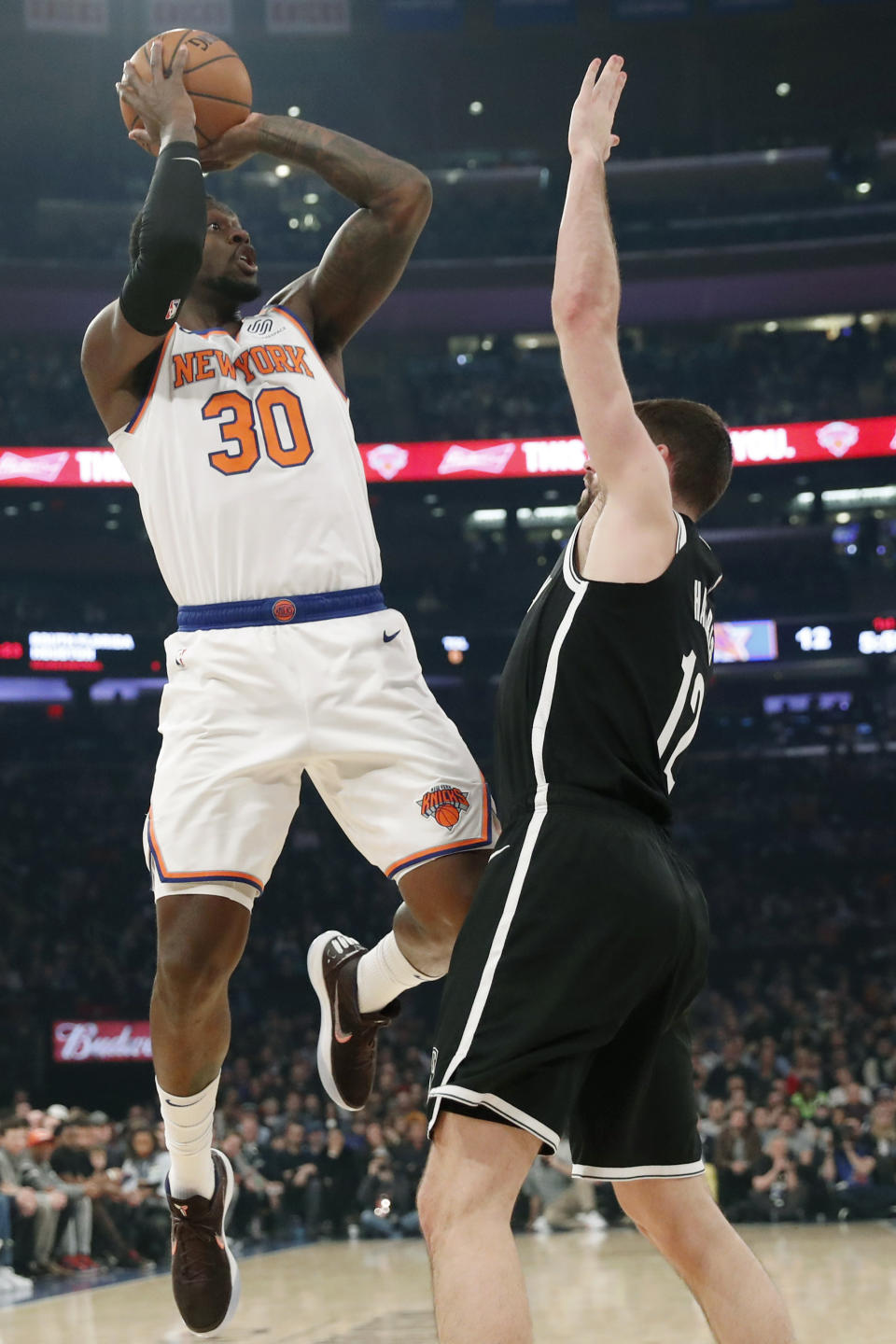 New York Knicks forward Julius Randle (30) attempts a three-point shot over Brooklyn Nets forward Joe Harris (12) during the first half of an NBA basketball game in New York, Sunday, Jan. 26, 2020. (AP Photo/Kathy Willens)