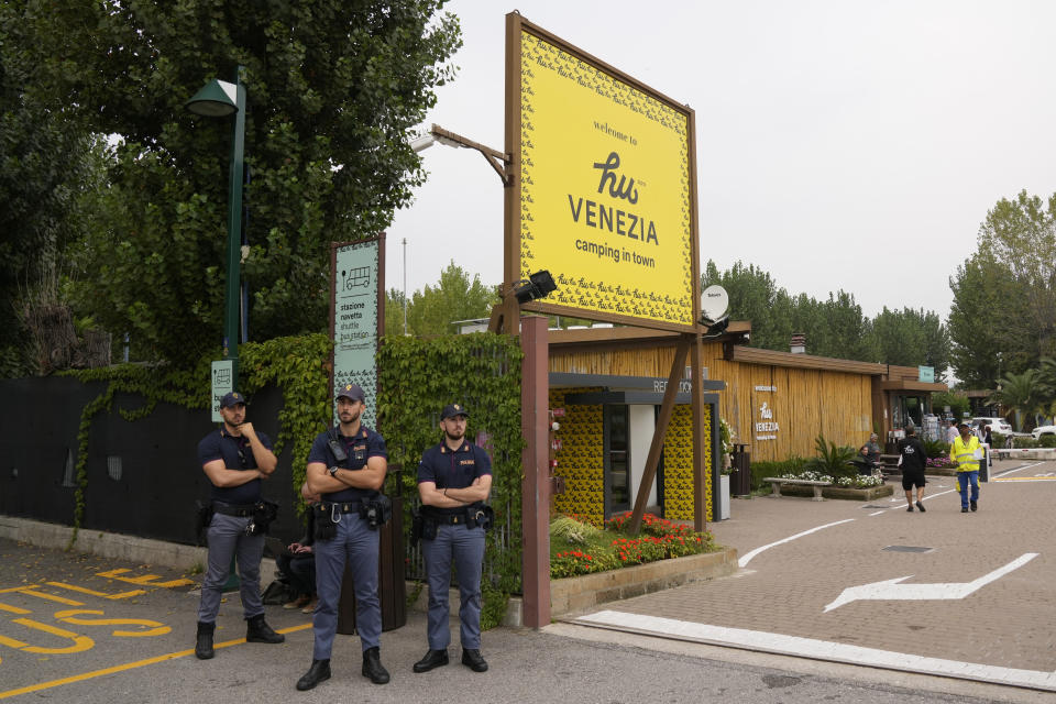 Police officers stand guard outside the Camping Hu, where the bus passengers stay, in Mestre, near the city of Venice, Italy, Wednesday, Oct. 4, 2023. The bus fell from an elevated road, late Tuesday, killing multiple people. (AP Photo/Antonio Calanni)