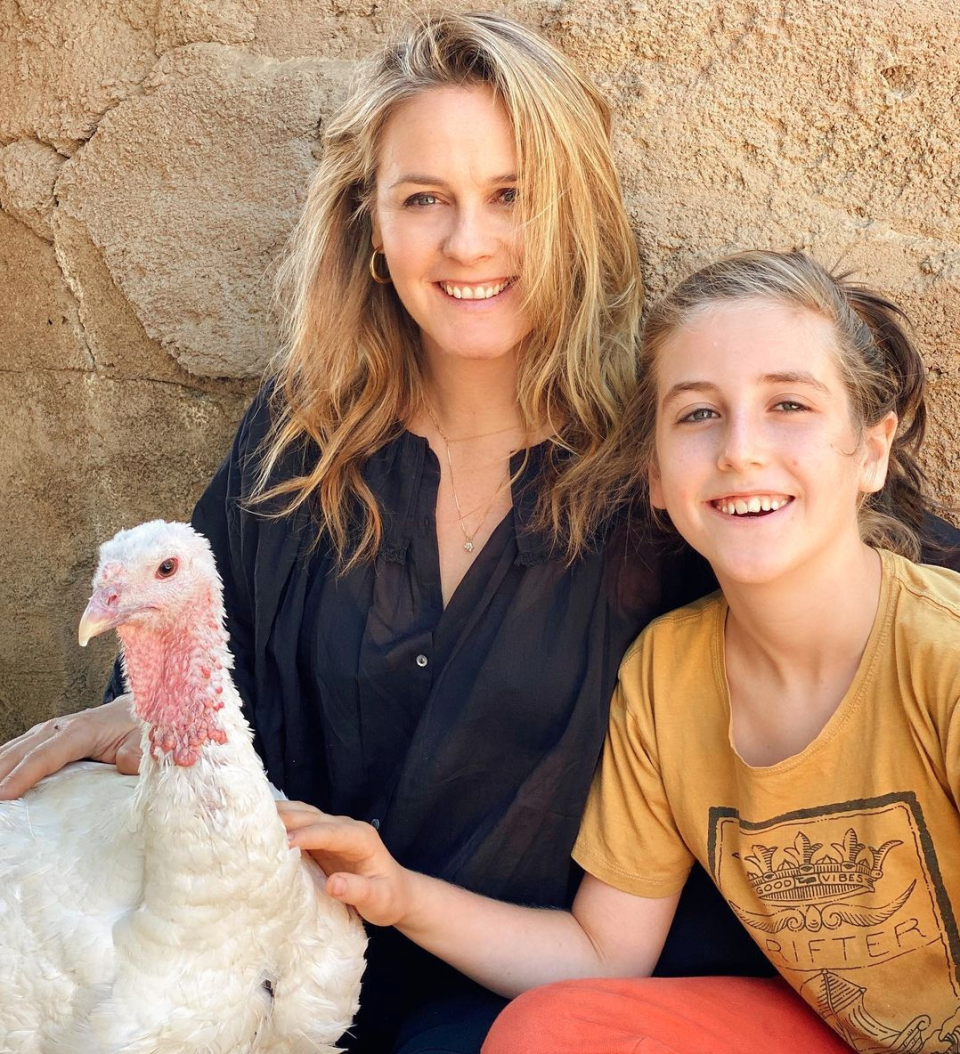 Alicia silverstone sitting next to her son Bear and a turkey