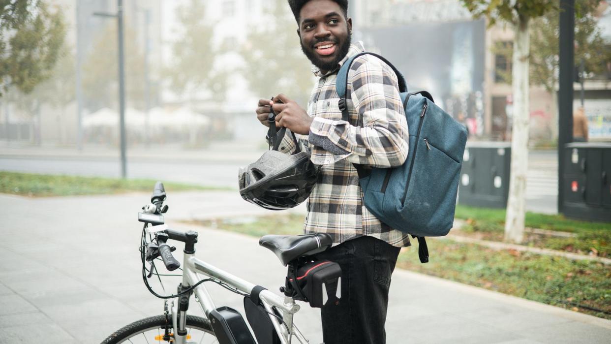 portrait of an african american man going to work on an electric bicycle