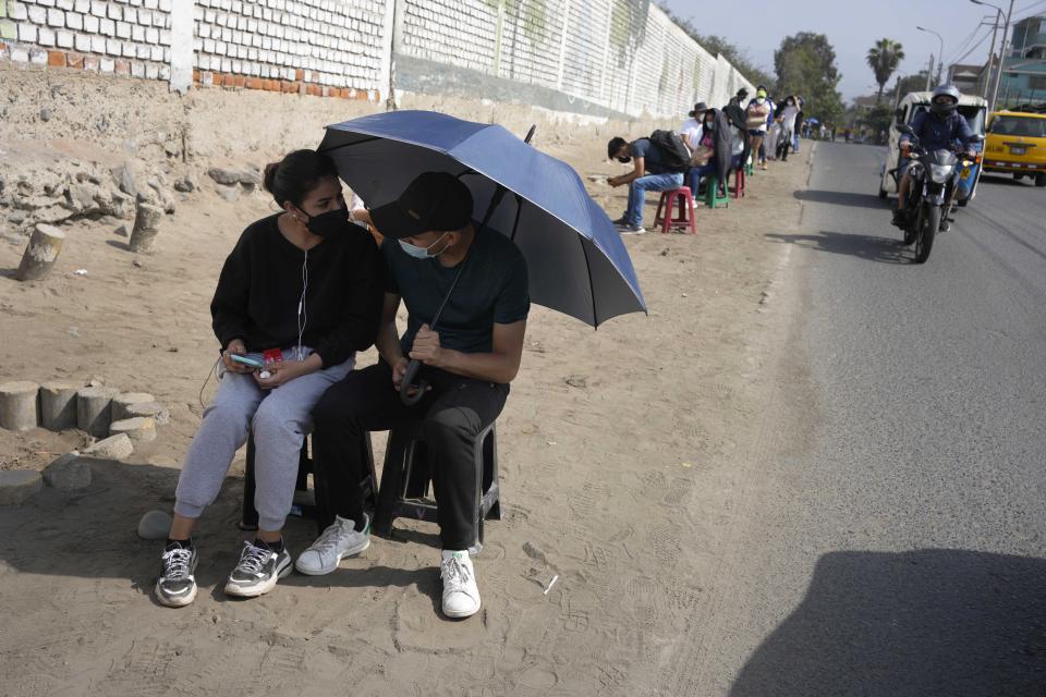 Residents wait to be tested for COVID-19 at a sports complex in the San Juan neighborhood of Lima, Peru, Tuesday, Jan. 11, 2022. Authorities in Peru are confirming a third wave of the pandemic. (AP Photo/Martin Mejia)