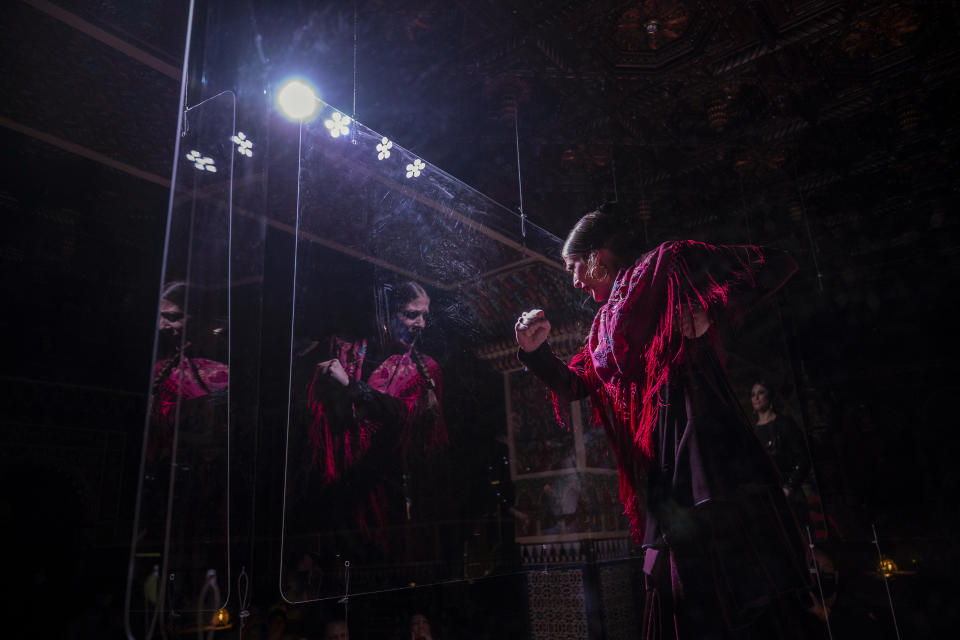 Flamenco dancer Marina Perez performs behind screens during a flamenco show at the Torres Bermejas "tablao," or live flamenco venue, in Madrid, Spain, Friday, Sept. 25, 2020. The passion and drama of live flamenco shows are back on stage in Madrid. But now the performers are behind Perspex screens and keeping their distance from the audience. The Torres Bermejas “tablao,” or live flamenco venue, has reopened its doors to customers after seven months closed due to the COVID-19 pandemic. (AP Photo/Manu Fernandez)