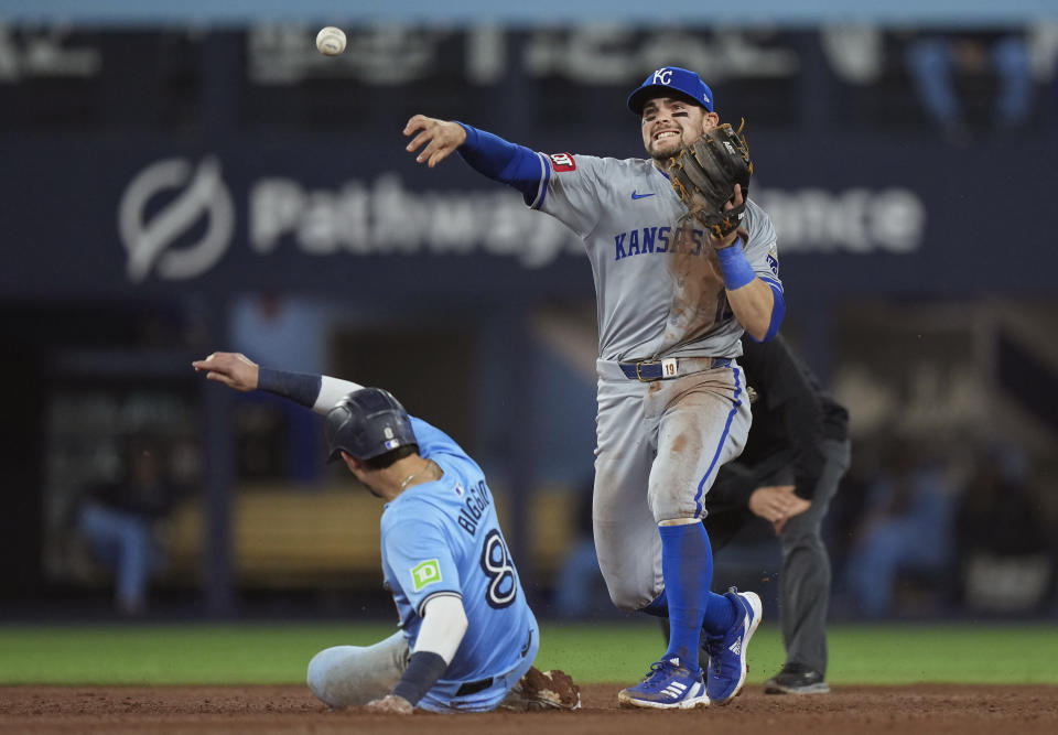 Kansas City Royals second baseman Michael Massey (19) forces out Toronto Blue Jays second baseman Cavan Biggio (8) at second base, then turns the double play over to first base to out Blue Jays shortstop Isiah Kiner-Falefa during the fifth inning of a baseball game in Toronto on Monday, April 29, 2024. (Nathan Denette/The Canadian Press via AP)