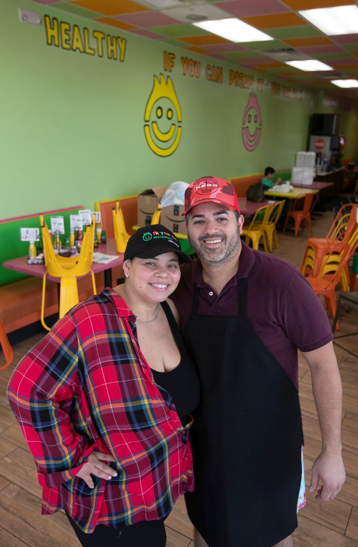 Melissa Muńiz and her husband Victor Serrano pose for a photo at FK Your Diet's Cape Coral location. The restaurants have been helping the community by serving free hot meals and giving out supplies donated by staff and customers.