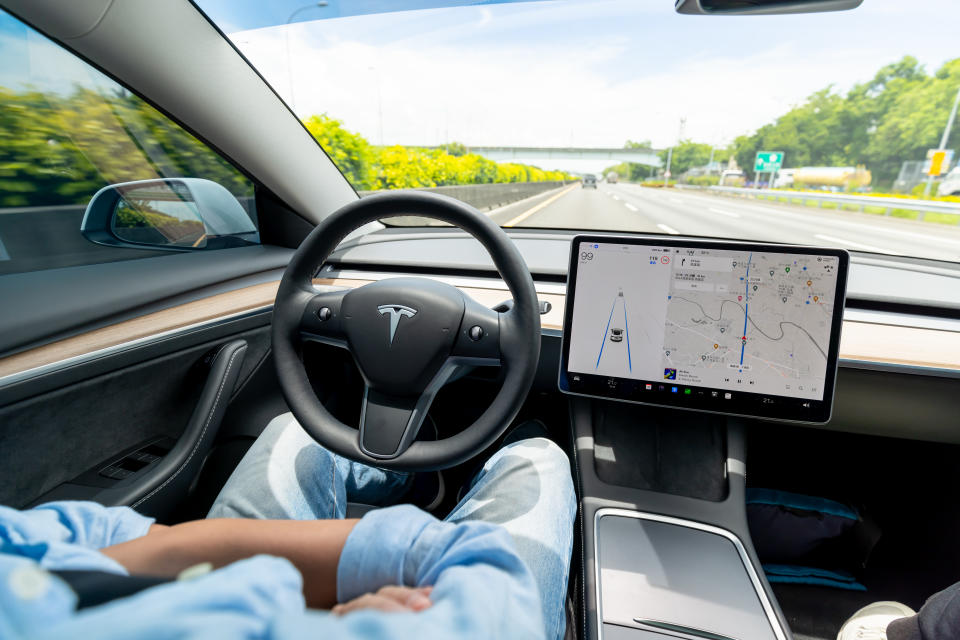 Koahsiung, Taiwan - June, 16, 2022: Man using automatic driving car on highway