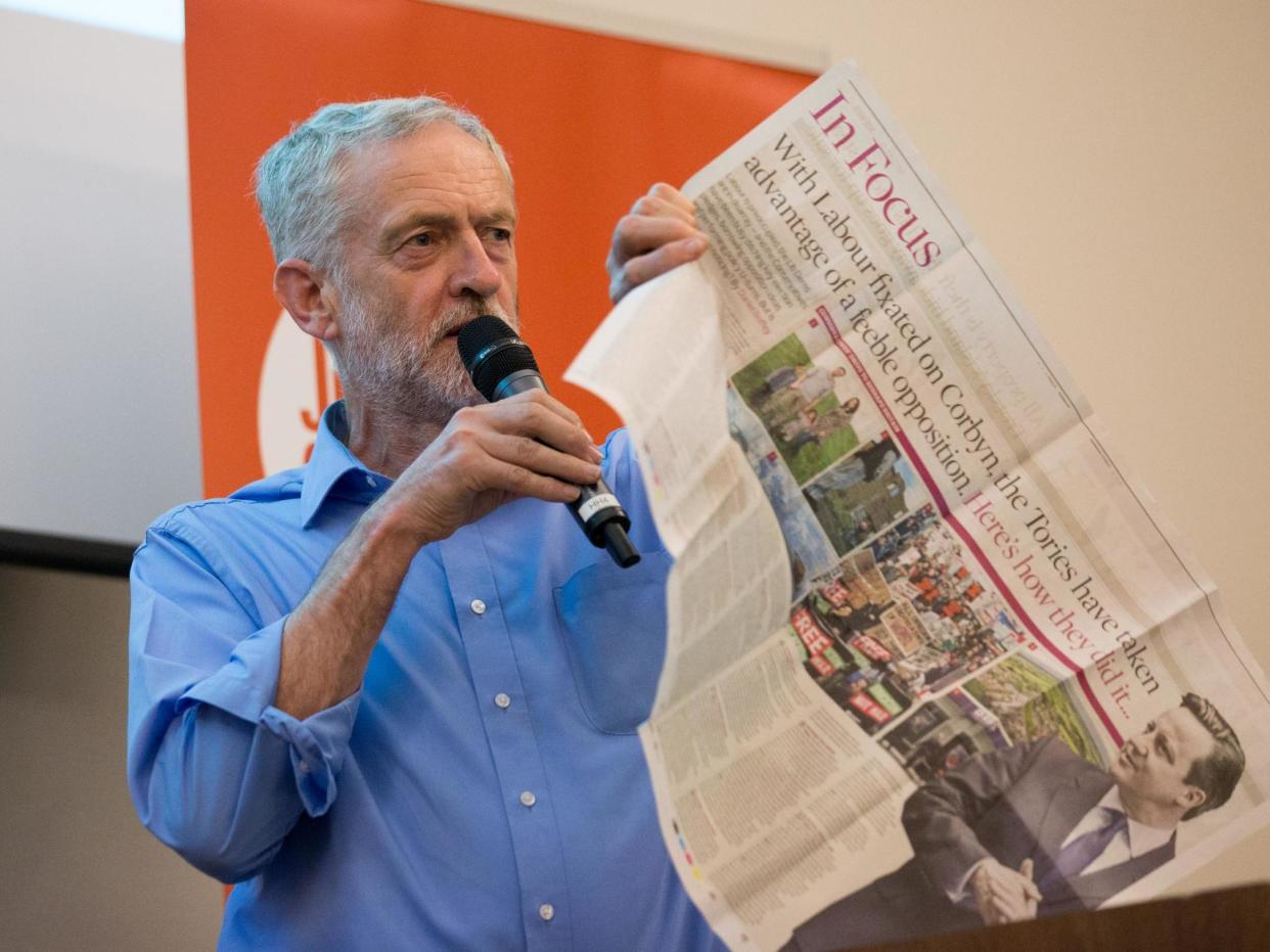 Jeremy Corbyn shows supporters a negative newspaper article on 25 August 2015: Getty Images