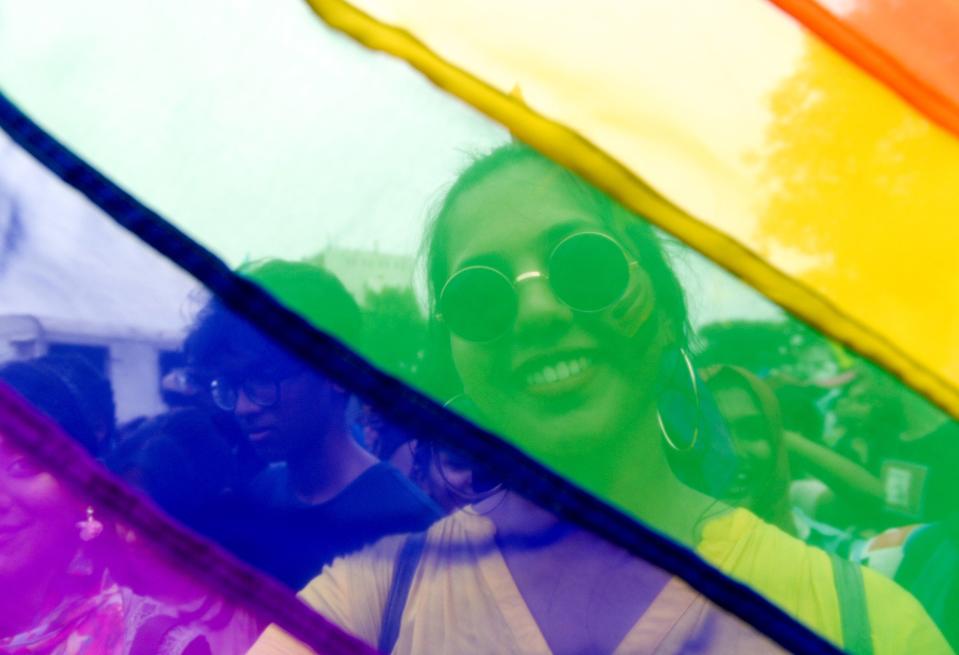 An Indian supporter of the lesbian, gay, bisexual, transgender (LGBT) community looks on through a rainbow flag as she takes part in a pride parade in Chennai on June 30, 2019. (Photo by ARUN SANKAR / AFP) (Photo credit should read ARUN SANKAR/AFP via Getty Images)