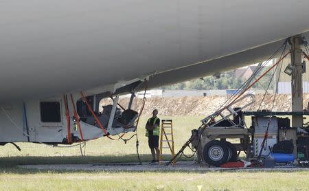 A man looks at damage to the Airlander 10 hybrid airship after a test flight at Cardington Airfield in Britain, August 24, 2016. REUTERS/Darren Staples