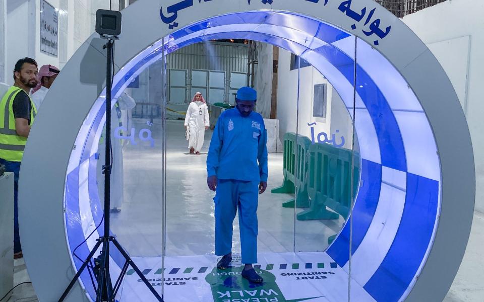 A worker passes through a self-sterilisation gate set up at an entrance of the Kaaba and the Grand Mosque - STR/AFP via Getty Images