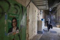 This Friday, Sept. 27, 2019 photo shows election campaign poster of Heba Yazbak, a newly elected Balad party Israeli Arab lawmaker at the market in Nazareth, northern Israel. Electoral gains made by Arab parties in Israel, and their decision to endorse one of the two deadlocked candidates for prime minister, could give them new influence in parliament. But they also face a dilemma dating back to Israel's founding: How to participate in a system that they say relegates them to second-class citizens and oppresses their Palestinian brethren in Gaza and the occupied West Bank. (AP Photo/Oded Balilty)