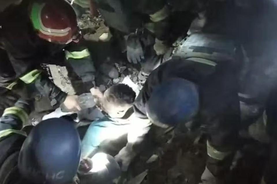 Ukrainian rescuers remove a doctor from the rubble of a hospital maternity ward (via REUTERS)