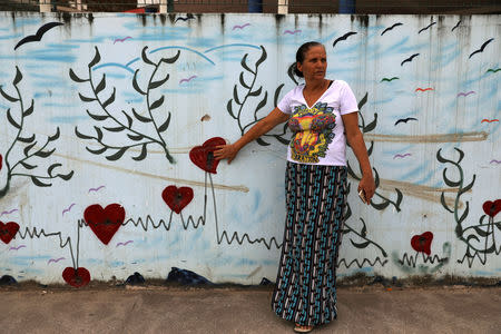 Rosilene Alves touches bullet holes in a wall outside her daughter's school in the Pedreira slum in Rio de Janeiro, Brazil, April 22, 2018. Alves's daughter, Maria Eduarda Alves, was shot dead at school in 2017 when she was 13-years-old. REUTERS/Pilar Olivares