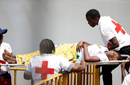 Mourner is carried on a stretcher during the state funeral of Mugabe at the national sports stadium in Harare