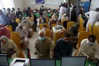 People wait for their turn to receive the second shot of the AstraZeneca COVID-19 vaccine at a vaccination center in Lahore, Pakistan, Sunday, May 16, 2021. (AP Photo/K.M. Chuadary)