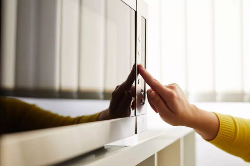 Woman using a microwave in the office