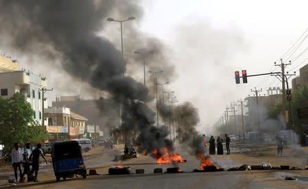 Sudanese protesters use burning tyres to erect a barricade on a street, demanding that the country's Transitional Military Council hand over power to civilians, in Khartoum