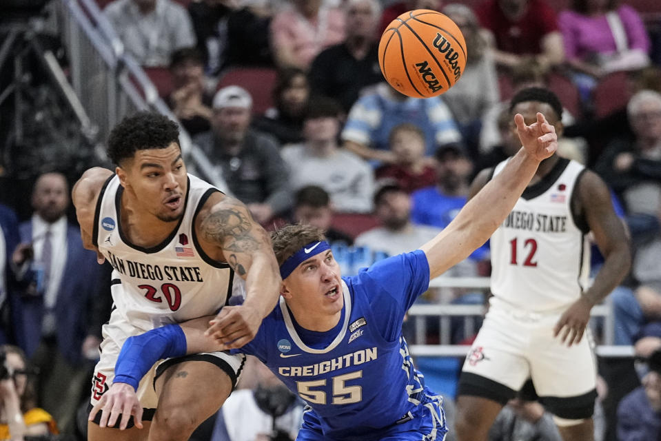 San Diego State guard Matt Bradley (20) and Creighton guard Baylor Scheierman (55) vie for a loose ball in the second half of a Elite 8 college basketball game in the South Regional of the NCAA Tournament, Sunday, March 26, 2023, in Louisville, Ky. (AP Photo/John Bazemore)