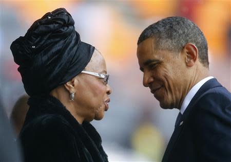 U.S. President Barack Obama pays his respect to Mandela's widow Graca Machel after his speech at the memorial service for late South African President Nelson Mandela at the FNB soccer stadium in Johannesburg December 10, 2013. World leaders, from U.S. President Barack Obama to Cuba's Raul Castro, will pay homage to Mandela at the memorial that will recall his gift for bringing enemies together across political and racial divides. REUTERS/Kai Pfaffenbach