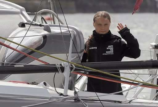 Swedish climate activist Greta Thunberg waves from aboard the Malizia II IMOCA class sailing yacht which is taking her to New York