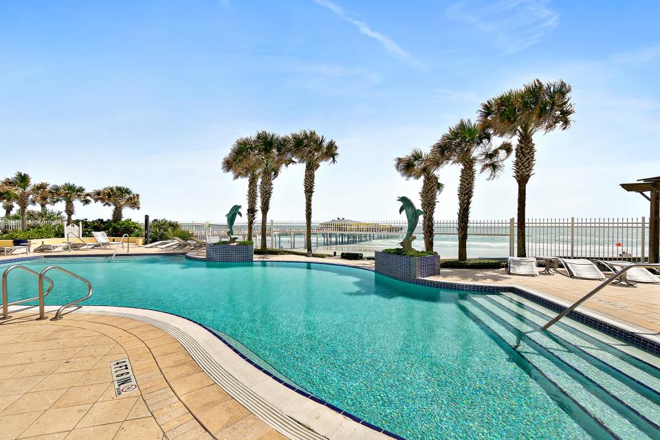 Two dolphin sculpures stand guard over this sparkling and inviting pool.