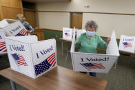 Marty Goetz, right, and Diane White, prepare the voting screens as they start to set up a polling place Monday, June 1, 2020, for the voting for Tuesday's Pennsylvania primary in Jackson Township near Zelienople, Pa. (AP Photo/Keith Srakocic)