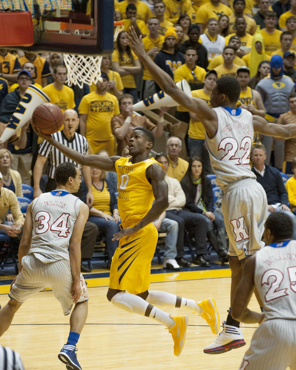 West Virginia's Eron Harris, left, drives by Kansas' Andrew Wiggins during the first half of an NCAA college basketball game Saturday, March 8, 2014, in Morgantown, W.Va. (AP Photo/Andrew Ferguson)