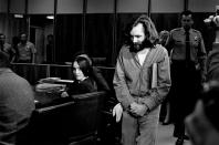 <p>Charles Manson walks into the courtroom in Santa Monica, Calif., on Oct. 13, 1970. Manson and Susan Atkins, seated, a member of his family of followers, were to plead on charges of murdering a Malibu musician, Gary Hinman. When his name was called, Manson stood, folded his arms, and turned his back on the judge. Atkins did the same. The court then entered pleas of not guilty. Both were on trial in Los Angeles for killings that included actress Sharon Tate. (Photo: AP) </p>