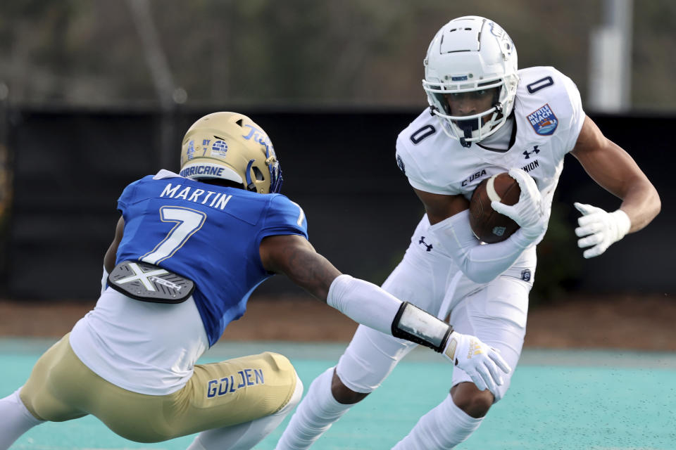 Old Dominion's Ali Jennings III (0) runs the ball against the defense of Tulsa's TieNeal Martin (7) in the first half of an NCAA college football game in the Myrtle Beach Bowl in Conway, S.C., Monday, Dec. 20, 2021. (AP Photo/Mic Smith)