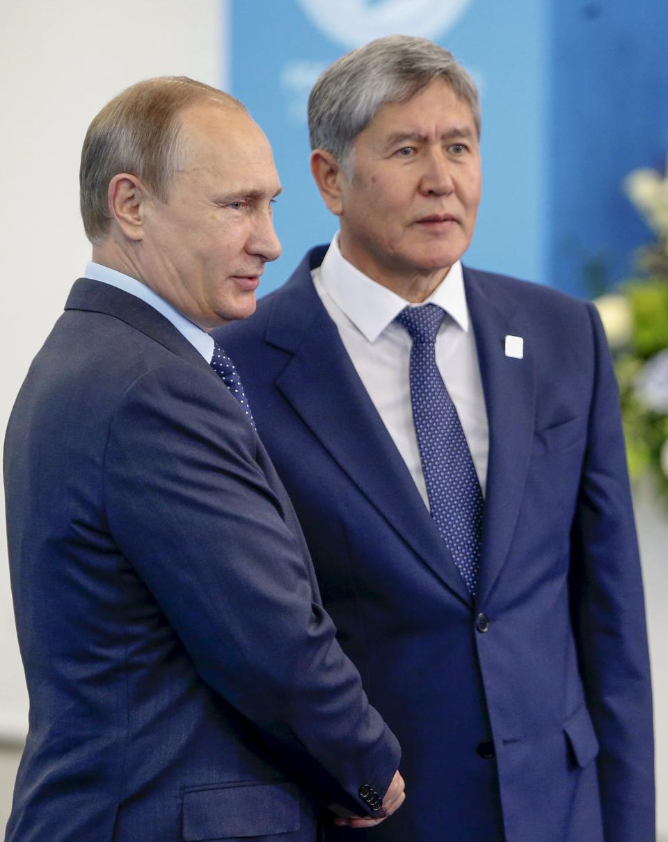 Russia's President Vladimir Putin (L) shakes hands with Kyrgyzstan's President Almazbek Atambayev during the Shanghai Cooperation Organization (SCO) summit in Ufa, Russia, July 10, 2015. REUTERS/Sergei Karpukhin