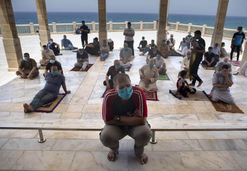 Palestinians wearing face masks attend the last Friday noon Prayer of the holy month of Ramadan, in a mosque in Gaza City, Friday, May. 22, 2020. After nearly two months of closure due to the coronavirus, Gaza's Hamas rulers decided to partially reopen mosques for the Friday noon prayer. (AP Photo/Khalil Hamra)