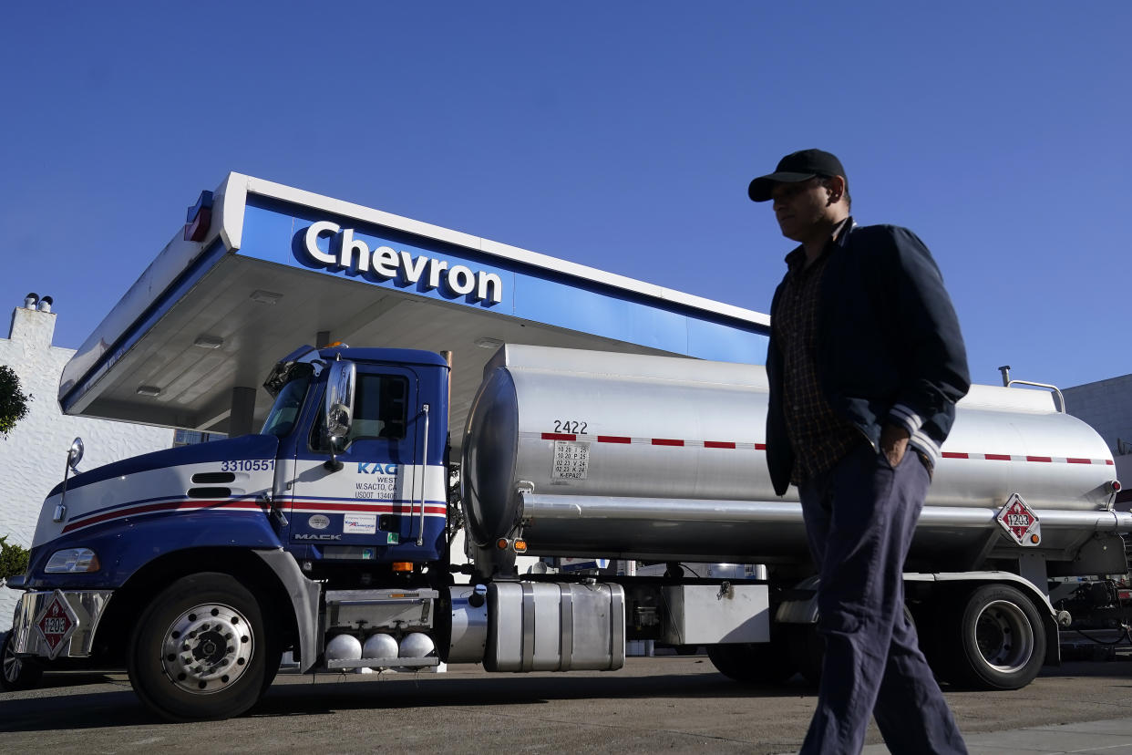 A pedestrian walks past a tanker at a Chevron gas station in San Francisco, Monday, Oct. 23, 2023. Chevron is buying Hess Corp. for $53 billion as major producers seize the initiative while oil prices surge. (AP Photo/Jeff Chiu)