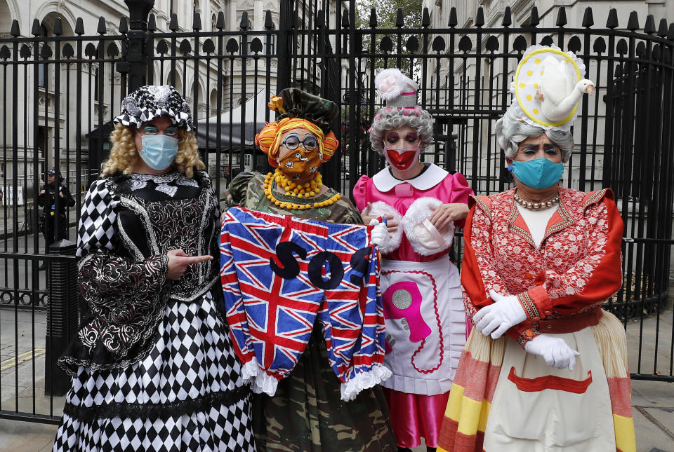 Actores vestidos como damas de la pantomima británica posan para fotógrafos antes de marchar hasta el Parlamento para exigir un mayor apoyo al sector teatral durante la pandemia de coronavirus, el miércoles 30 de septiembre del 2020 en Londres. (AP Foto/Frank Augstein)