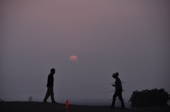 Two student archaeologists atop the Chinca Valley Mono B mound on June 20, 2013, the day before the winter solstice. On the solstice day, the sun would fall on the heads of those on the mound when viewed from behind the structure, archaeologist