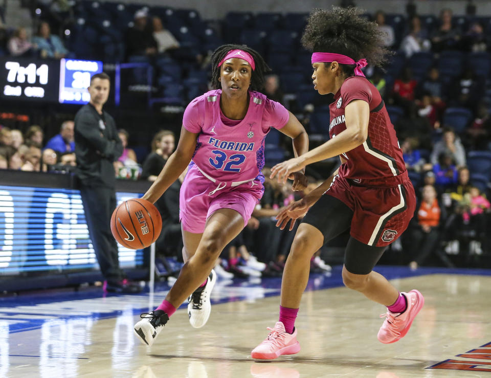 Florida guard Ariel Johnson (32) advances the ball while defended by South Carolina guard Destanni Henderson (3) during the first half of an NCAA college basketball game Thursday, Feb. 27, 2020, in Gainesville, Fla. (AP Photo/Gary McCullough)