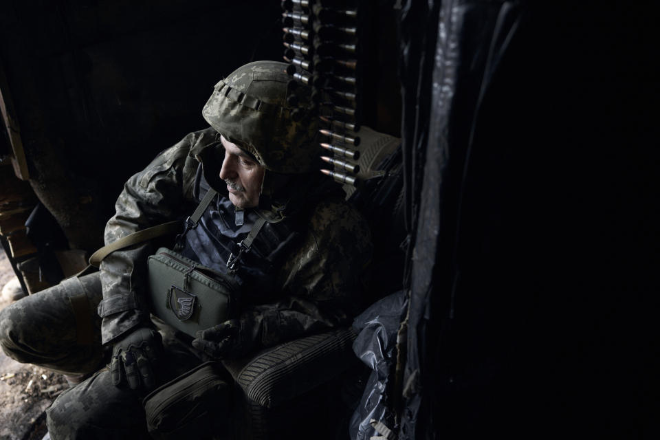 A Ukrainian soldier sits in his position during fights with Russian forces near Maryinka, Donetsk region, Ukraine, Friday, Dec. 23, 2022. (AP Photo/Libkos)