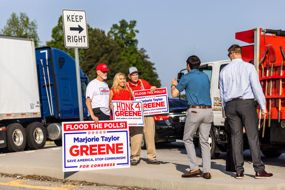 Greene waves signs with supporters on U.S. Highway 278 in Dallas, Ga.<span class="copyright">Andrew Hetherington for TIME</span>