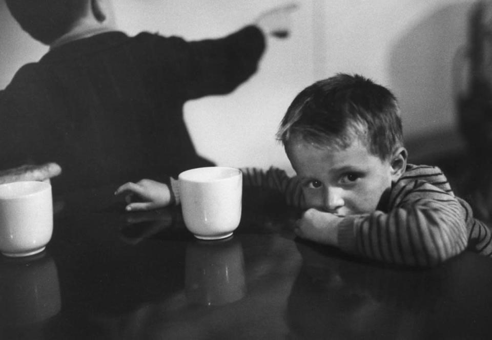 Caption from LIFE. "Tired child is ready to go to sleep with his head on the dining-hall table. American food is sometimes too strange for aliens. There is a kosher kitchen for orthodox Jews." (Alfred Eisenstaedt—Time & Life Pictures/Getty Images) <br> <br> <a href="http://life.time.com/history/ellis-island-rare-photos-from-the-gateway-to-a-new-world-1950/#1" rel="nofollow noopener" target="_blank" data-ylk="slk:Click here to see the full collection at LIFE.com;elm:context_link;itc:0;sec:content-canvas" class="link ">Click here to see the full collection at LIFE.com</a>