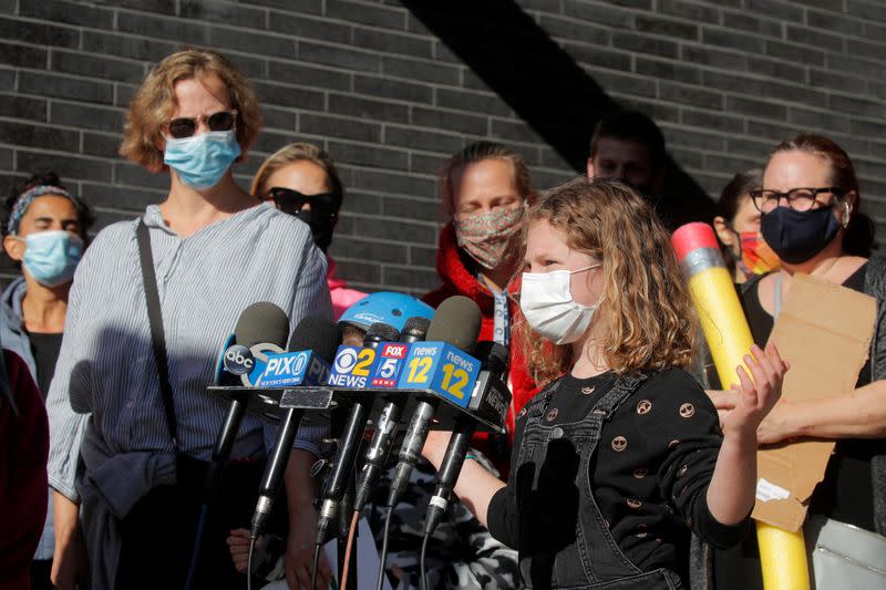 A child speaks to the press during a protest to the closing of Public School 130 outside the school building for safety reasons, following the outbreak of the coronavirus disease (COVID-19) in Brooklyn, New York