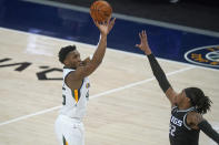 Utah Jazz guard Donovan Mitchell, left, shoots as Sacramento Kings center Richaun Holmes (22) defends in the first half during an NBA basketball game Saturday, April 10, 2021, in Salt Lake City. (AP Photo/Rick Bowmer)