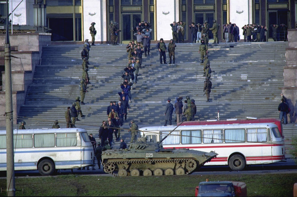 FILE - Hard-line defenders and supporters walk down the steps of the Russian Parliament building in Moscow with their hands raised after surrendering to forces loyal to Boris Yeltsin on Oct. 4, 1993. The October 1993 violent showdown between the Kremlin and supporters of the rebellious parliament marked a watershed in Russia's post-Soviet history. (AP Photo/Alexander Zemlianchenko, File)