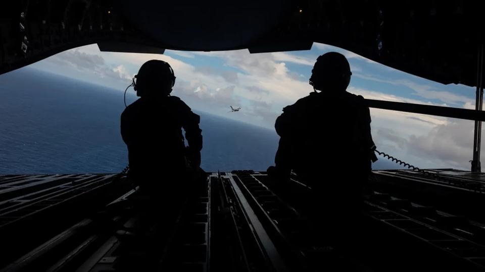 Royal Australian Air Force Cpl. Charlotte Roe, left, and U.S. Air Force Master Sgt. Jason Livingston, both C-17 loadmasters, watch other C-17s fly over the Commonwealth of the Northern Mariana Islands July 12 during Exercise Mobility Guardian 23. (Tech. Sgt. Sean Carnes/Air Force)