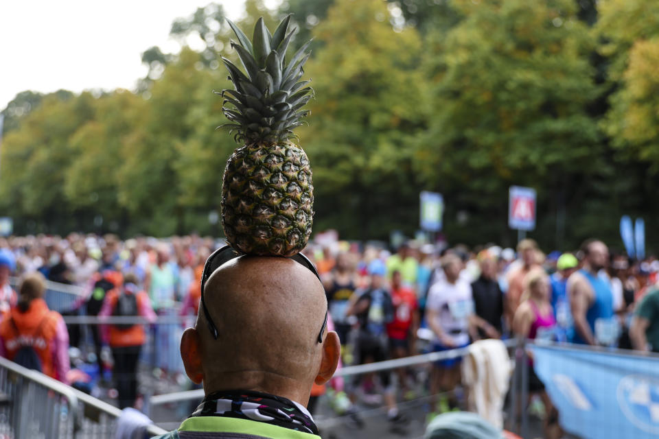 A man balances a pineapple on his head during the start period of the Berlin Marathon in Berlin, Germany, Sunday, Sept. 25, 2022. (AP Photo/Christoph Soeder)
