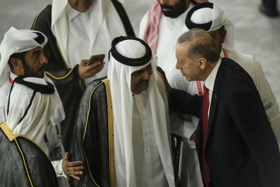 Former Emir of Qatar Sheikh Hamad bin Khalifa Al Thani, centre left, and Turkish President Recep Tayyip Erdogan, right, greet each other before the start of the World Cup, group A soccer match between Qatar and Ecuador at the Al Bayt Stadium in Al Khor, Qatar, Sunday, Nov. 20, 2022. (AP Photo/Hassan Ammar)