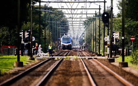 Members of the emergency services investigate the scene of a train crash with a cargo bike on a rail crossing in Oss - Credit: VINCENT JANNINK/AFP