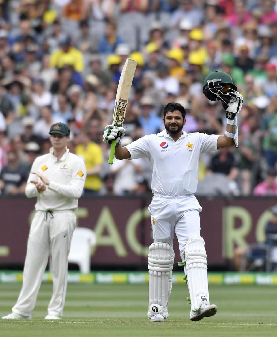 Pakistan's Azhar Ali celebrates scoring a century watched by Australian captain Steve Smith, left, on the second day of their second cricket test match in Melbourne, Australia, Tuesday, Dec. 27, 2016. (AP Photo/Andy Brownbill)