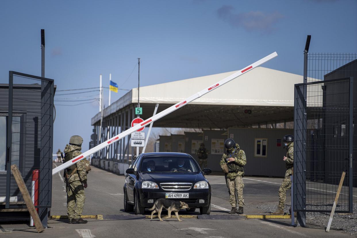 A car waits to cross a checkpoint from territory controlled by Russia-backed separatists to the territory controlled by Ukrainian forces in Novotroitske, eastern Ukraine, Monday, Feb. 21, 2022. World leaders are making another diplomatic push in hopes of preventing a Russian invasion of Ukraine, even as heavy shelling continues in Ukraine's east.