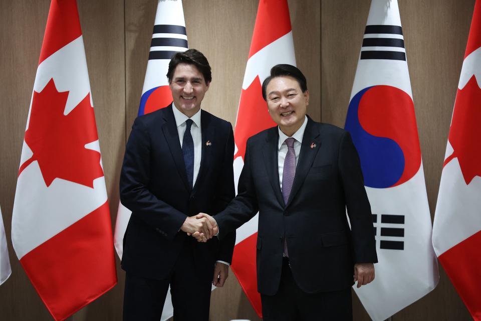 杜魯道（左）與南韓議長金振杓合照。（AFP）