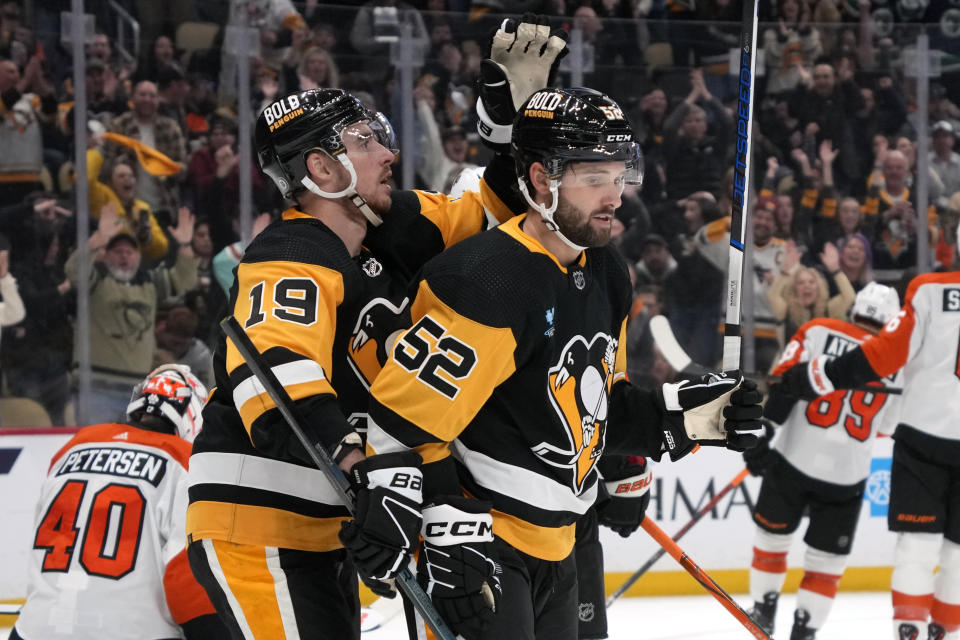 Pittsburgh Penguins' Emil Bemstrom (52) celebrates with Reilly Smith (19) after scoring his first goal with the Penguins during the second period of an NHL hockey game against the Philadelphia Flyers in Pittsburgh, Sunday, Feb. 25, 2024. (AP Photo/Gene J. Puskar)