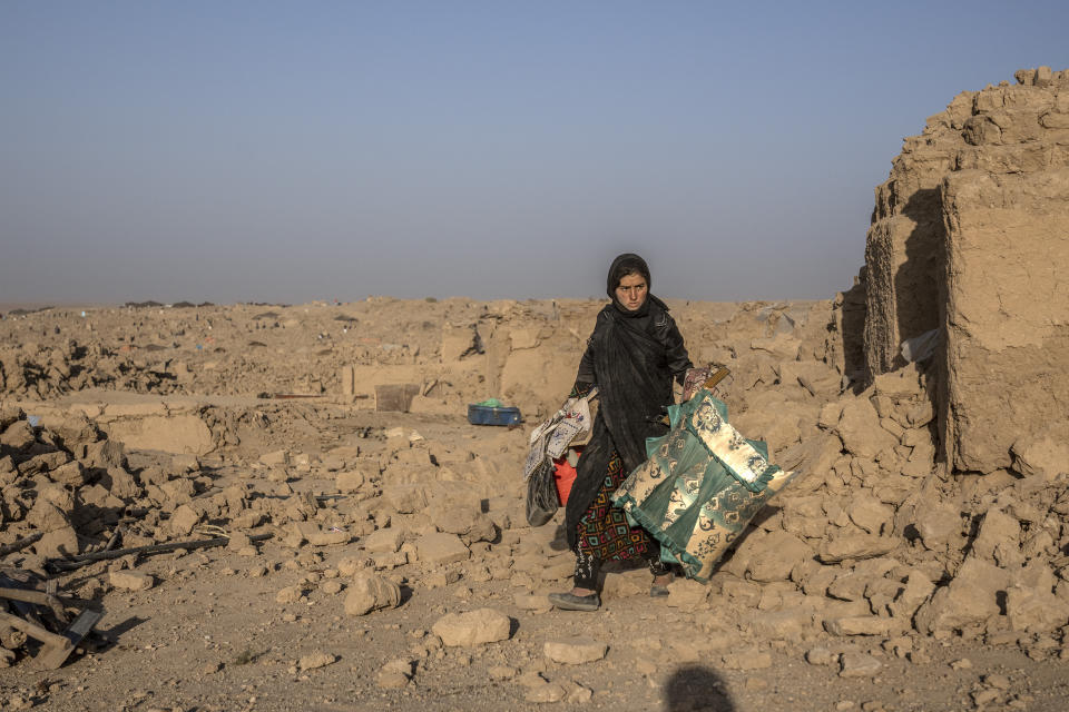 A girl cleans up rubble after an earthquake in Zenda Jan district in Herat province, western Afghanistan, Wednesday, Oct. 11, 2023. Another strong earthquake shook western Afghanistan on Wednesday morning after an earlier one killed more than 2,000 people and flattened whole villages in Herat province in what was one of the most destructive quakes in the country's recent history. (AP Photo/Ebrahim Noroozi)